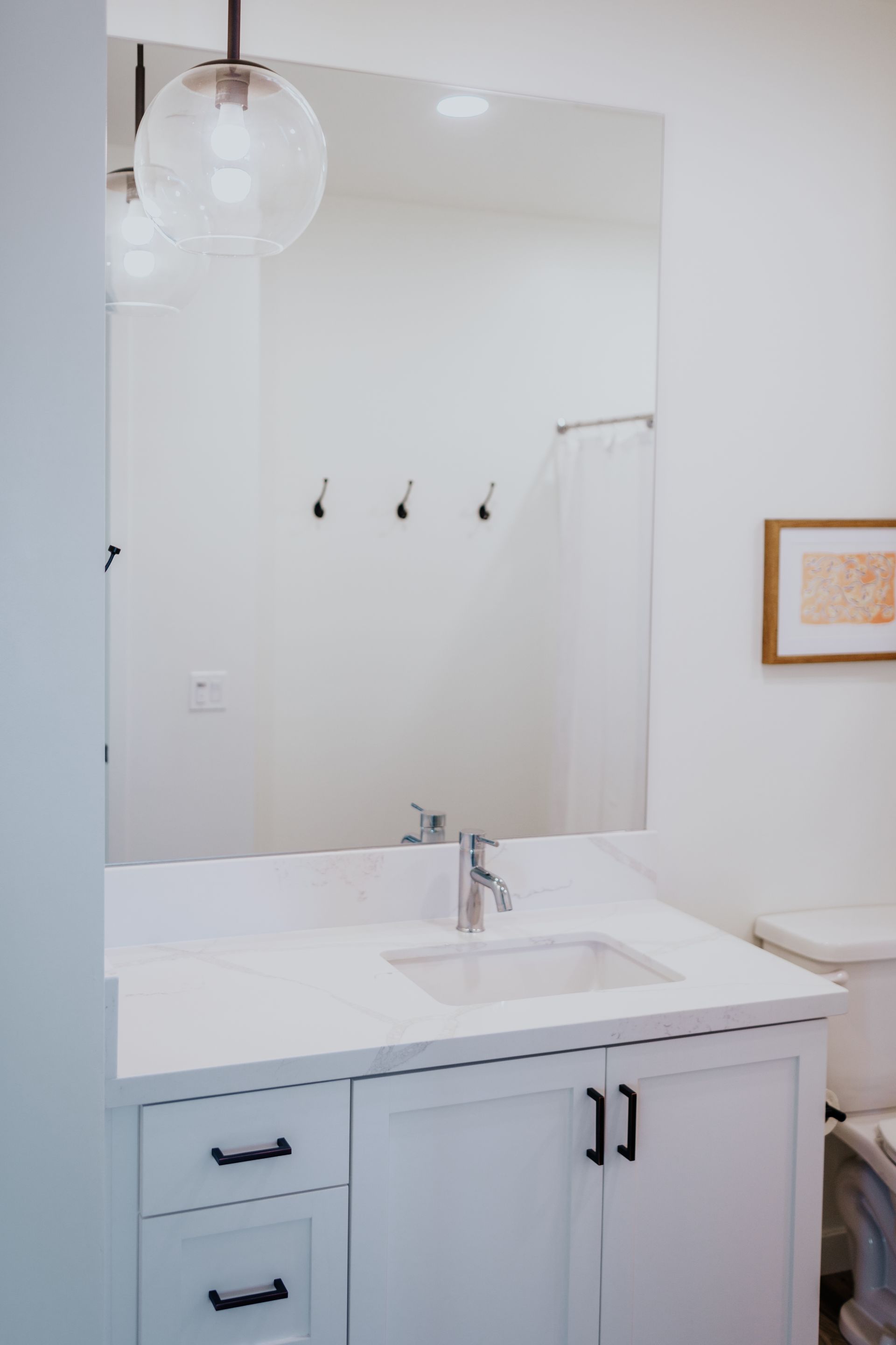 A bathroom with a sink , mirror and toilet.