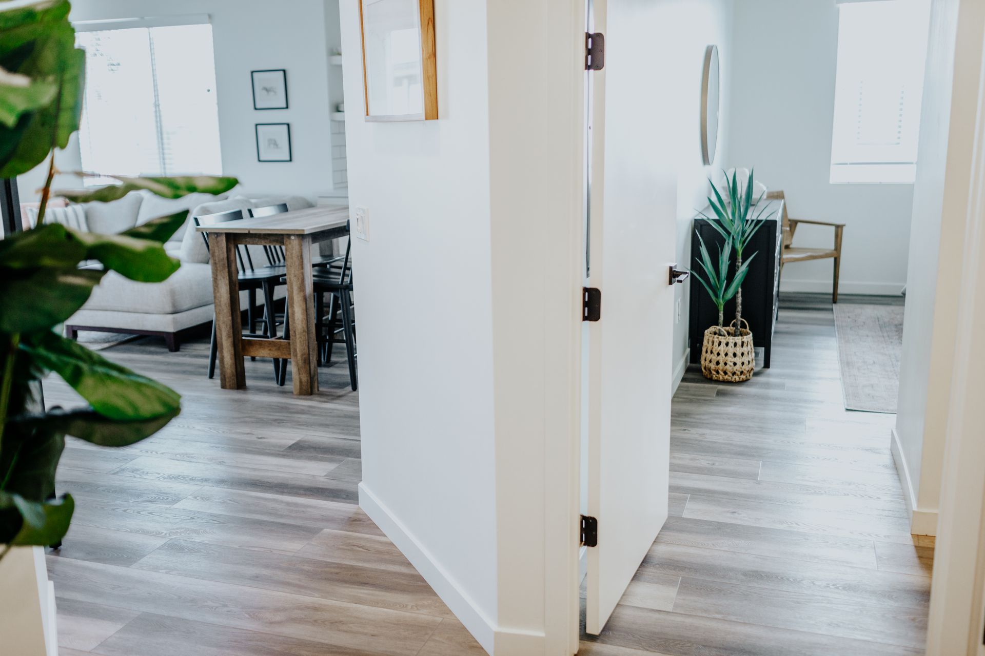 A hallway in a house leading to a living room and dining room.