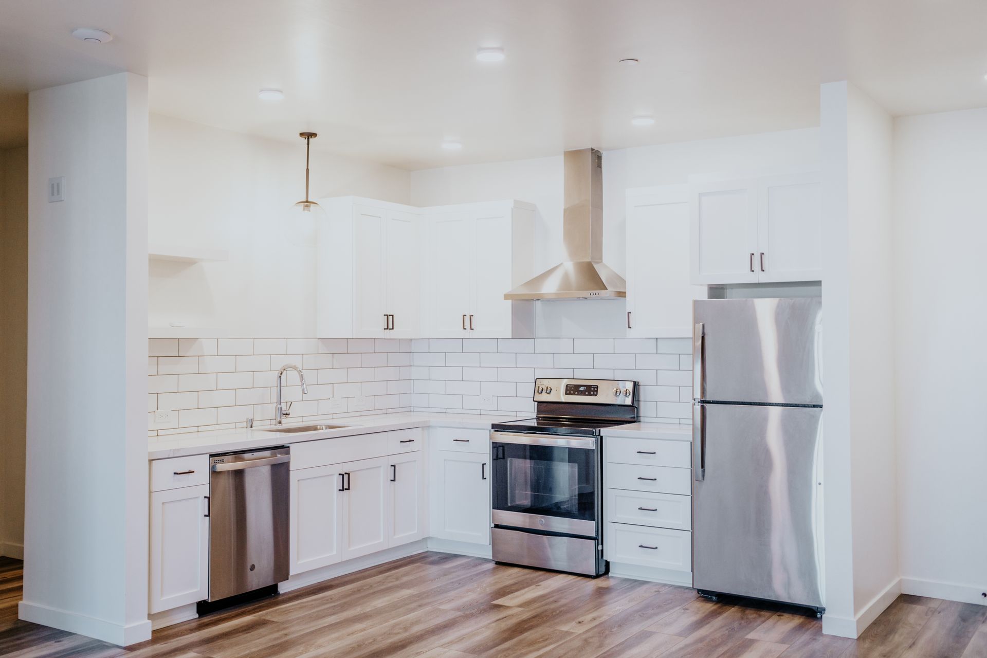 A kitchen with stainless steel appliances and white cabinets.