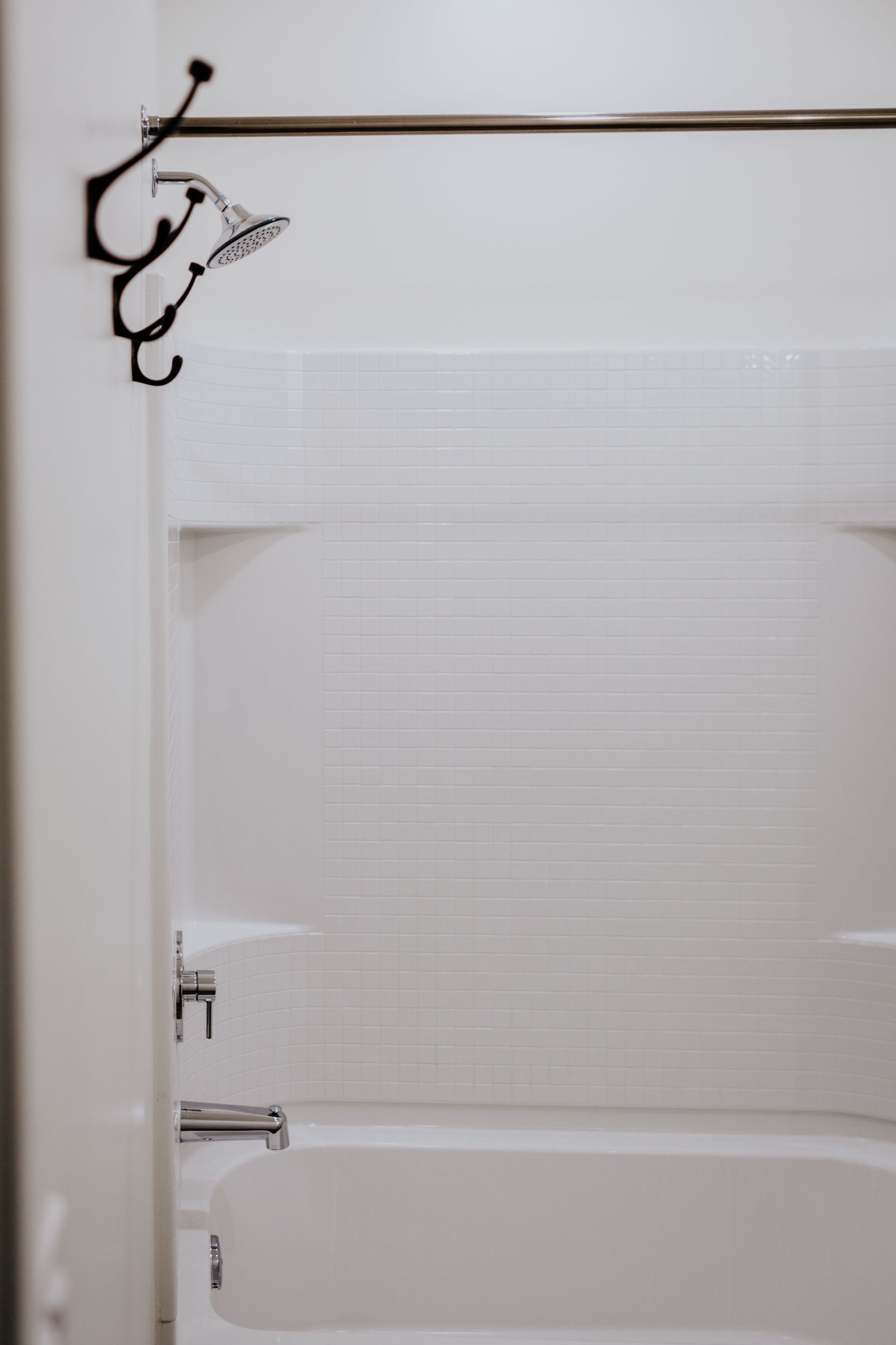 A bathroom with a bathtub and a shower head.