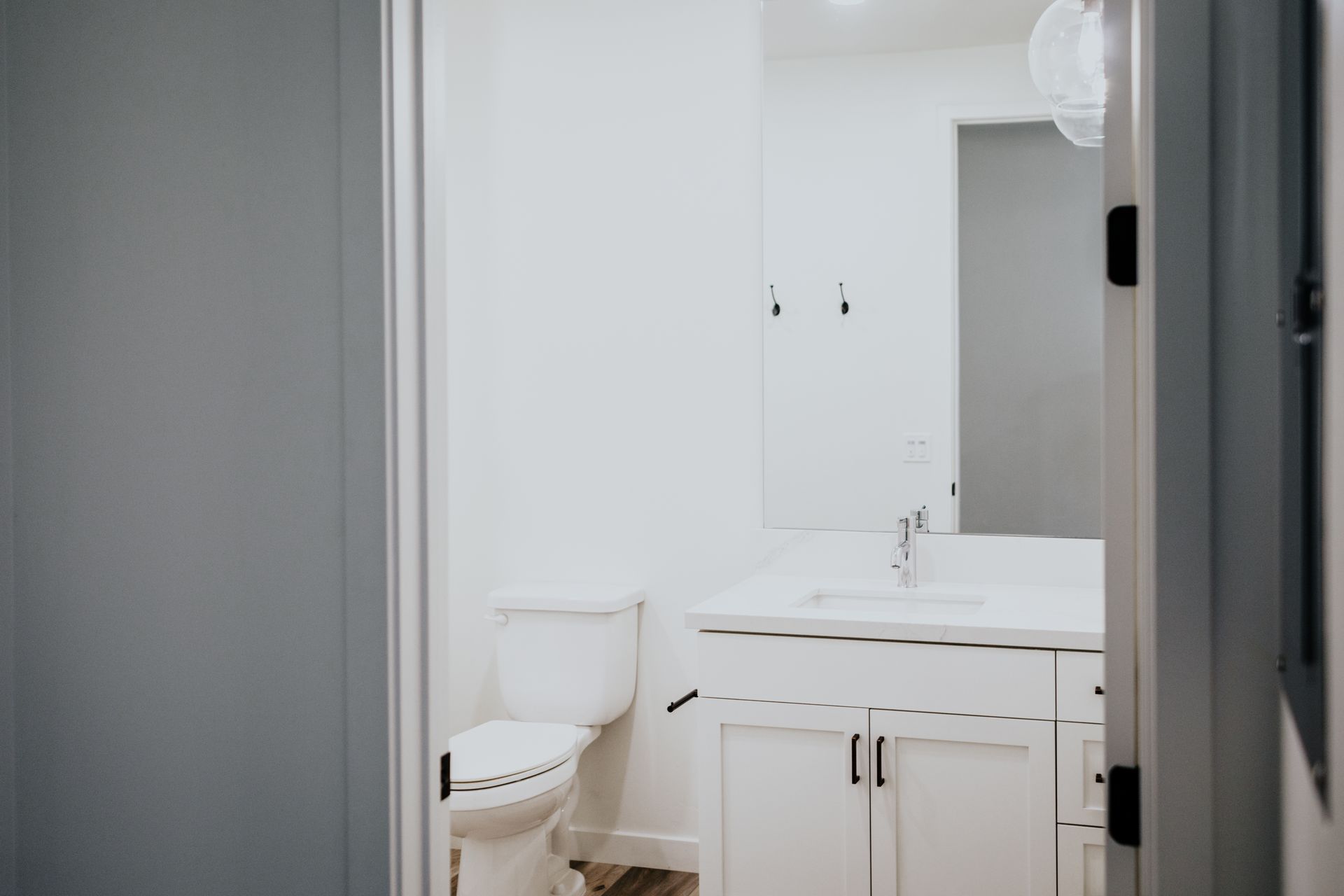 A bathroom with a toilet , sink and mirror.