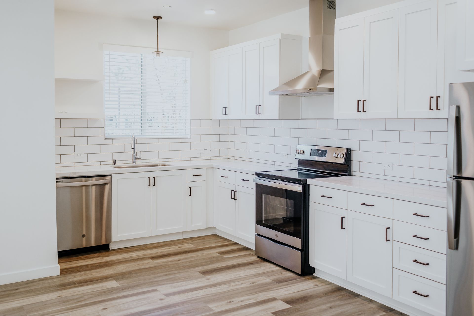 A kitchen with white cabinets and stainless steel appliances