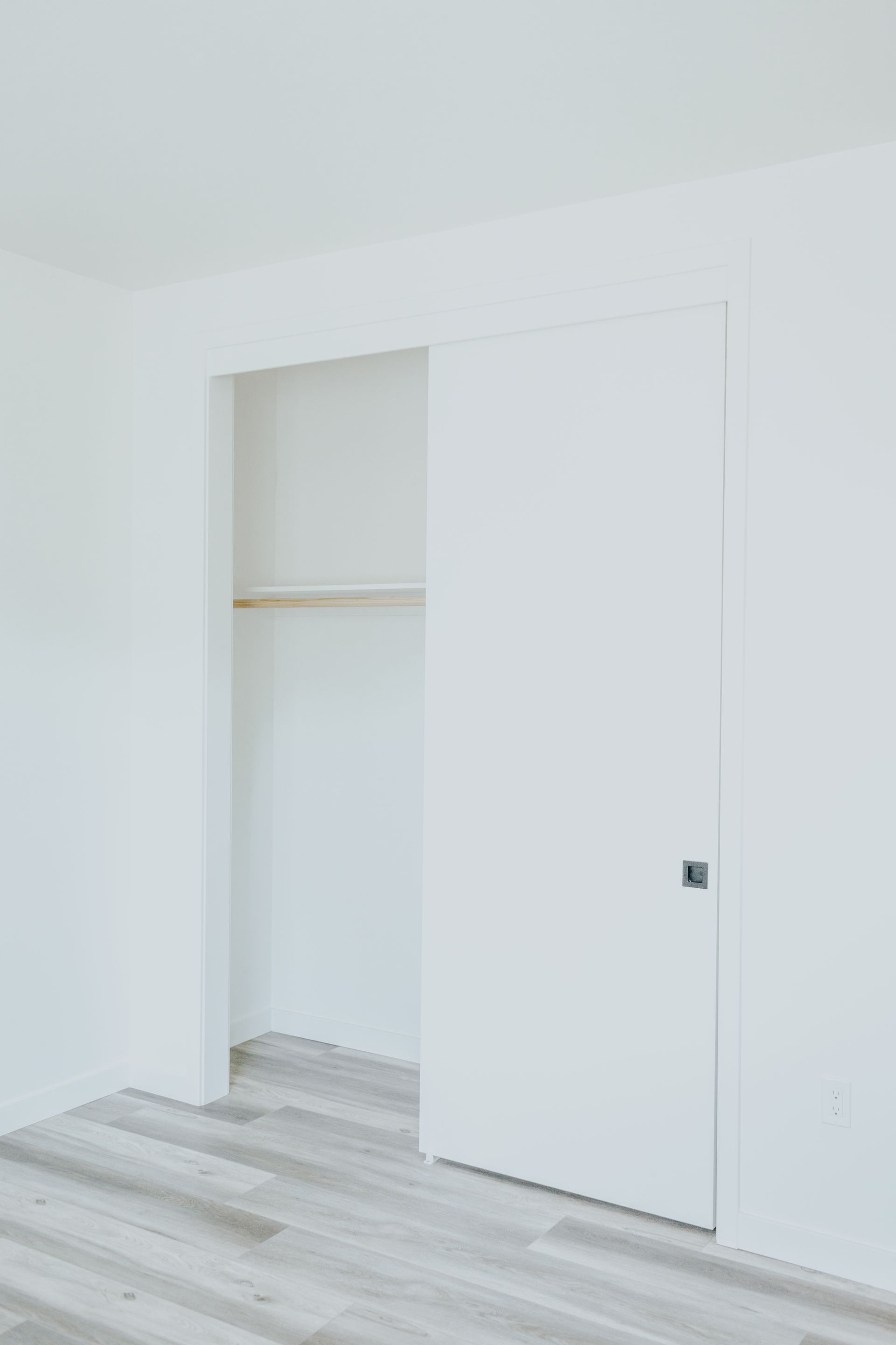 An empty room with a closet and a sliding door.