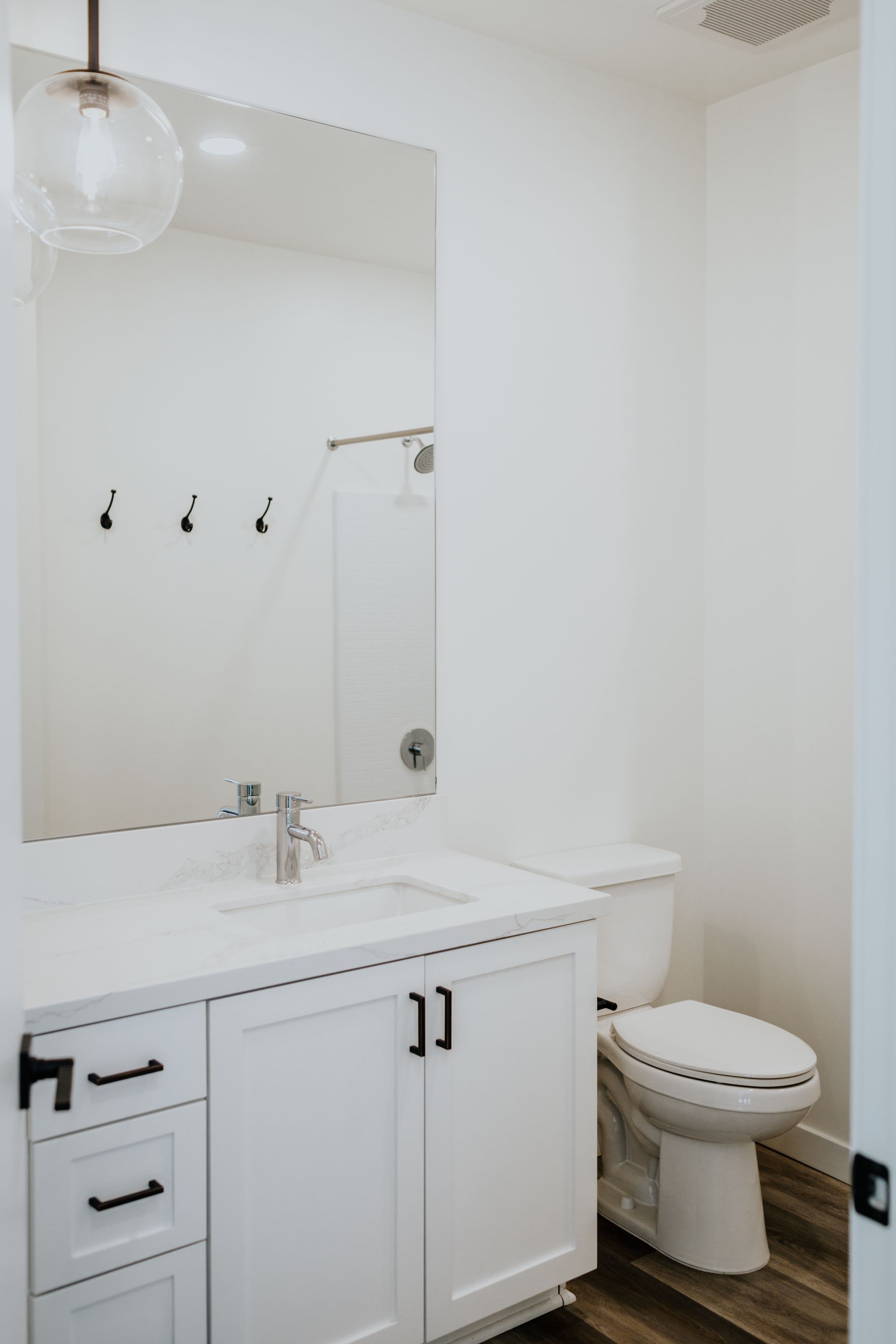 A bathroom with a sink , toilet and mirror.