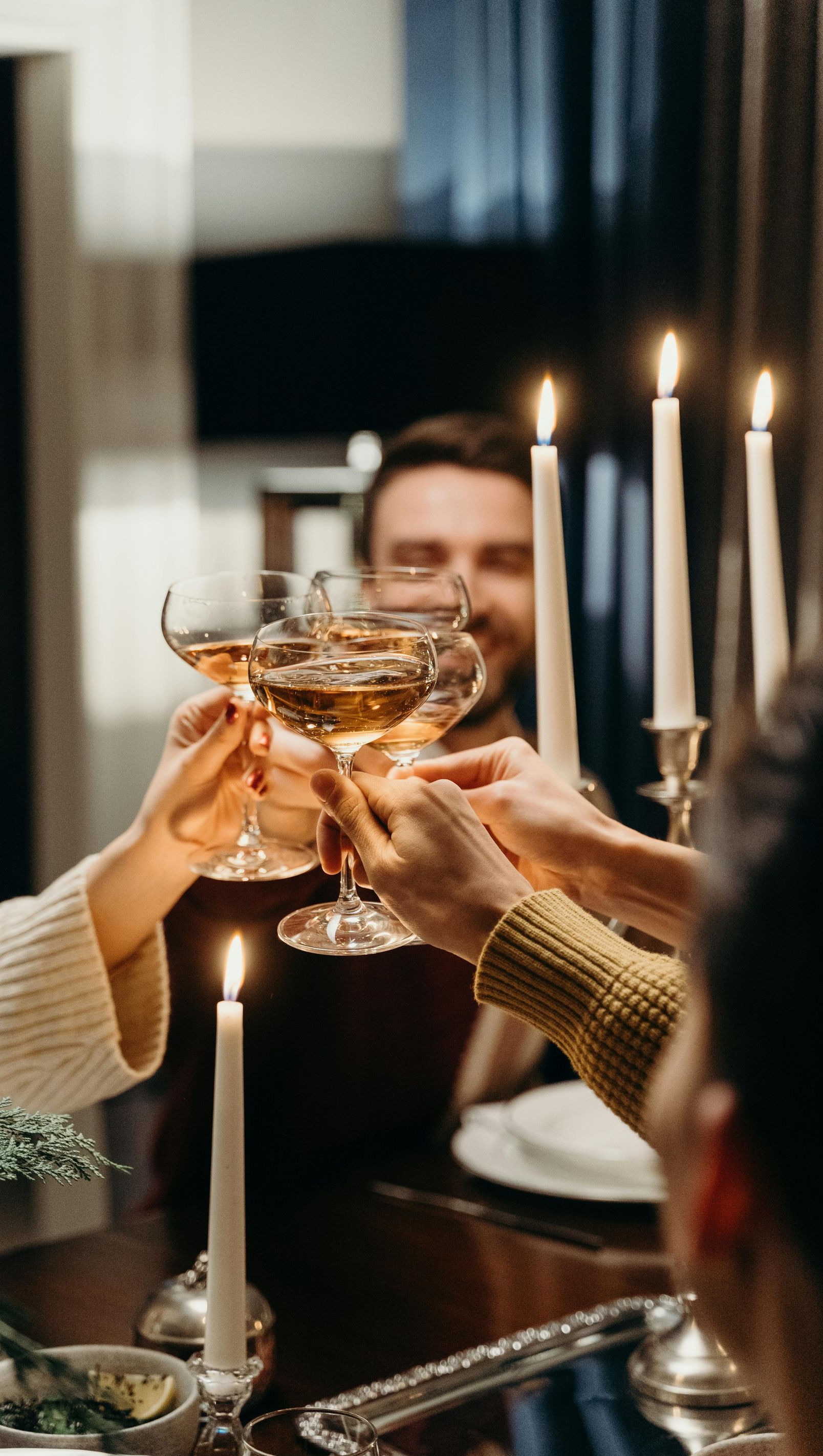 People toasting champagne glasses around a candlelit table.