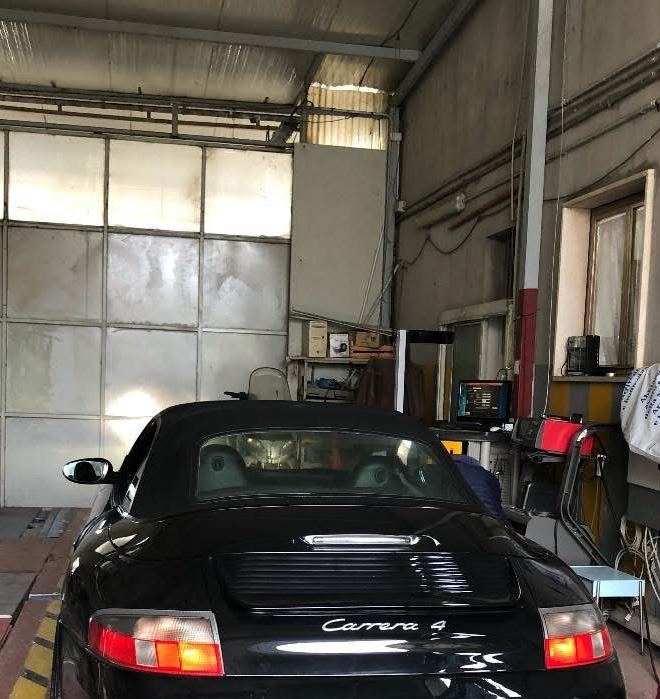 Porsche Carrera 4 decappottabile nera in un garage.