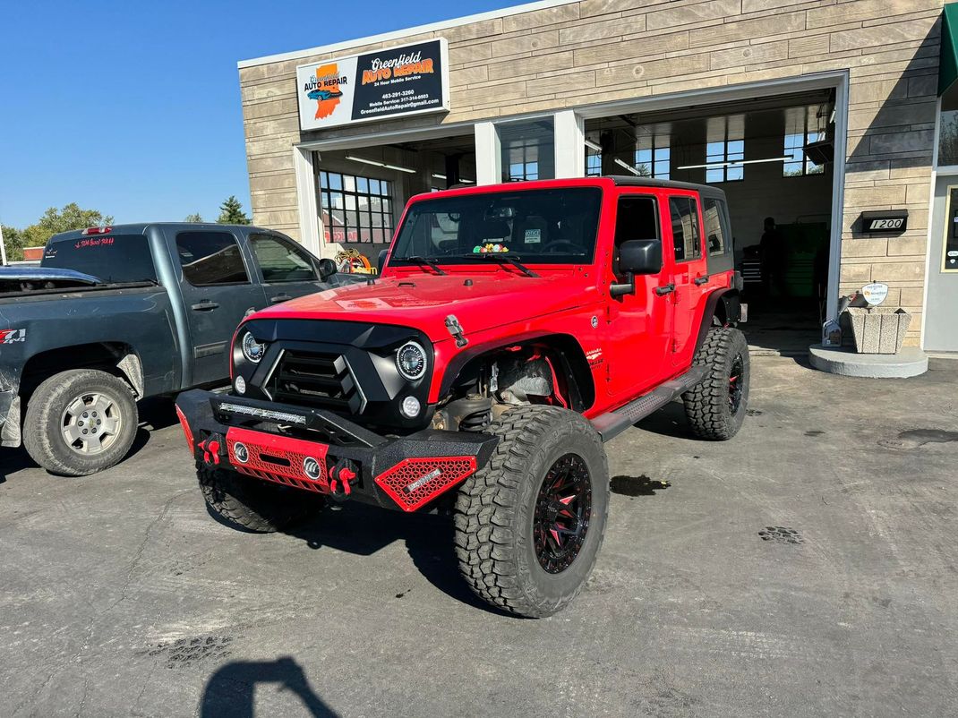 Red Jeep Gladiator With Lift Kit Parked Outside Shop | Greenfield Auto Repair