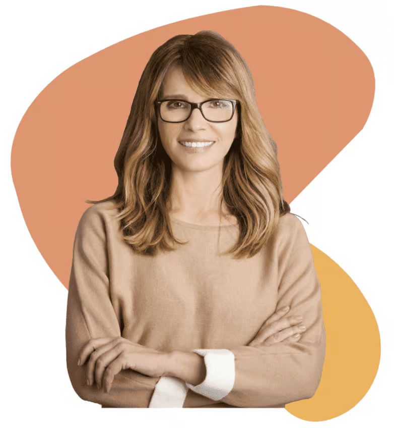 Two men discuss paperwork at a wooden table in a warehouse office with machinery in the background.