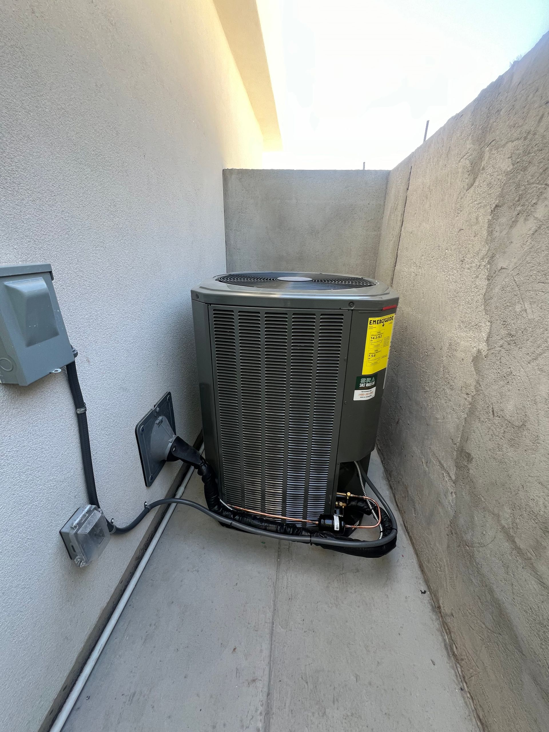 A large air conditioner is sitting on the side of a building.