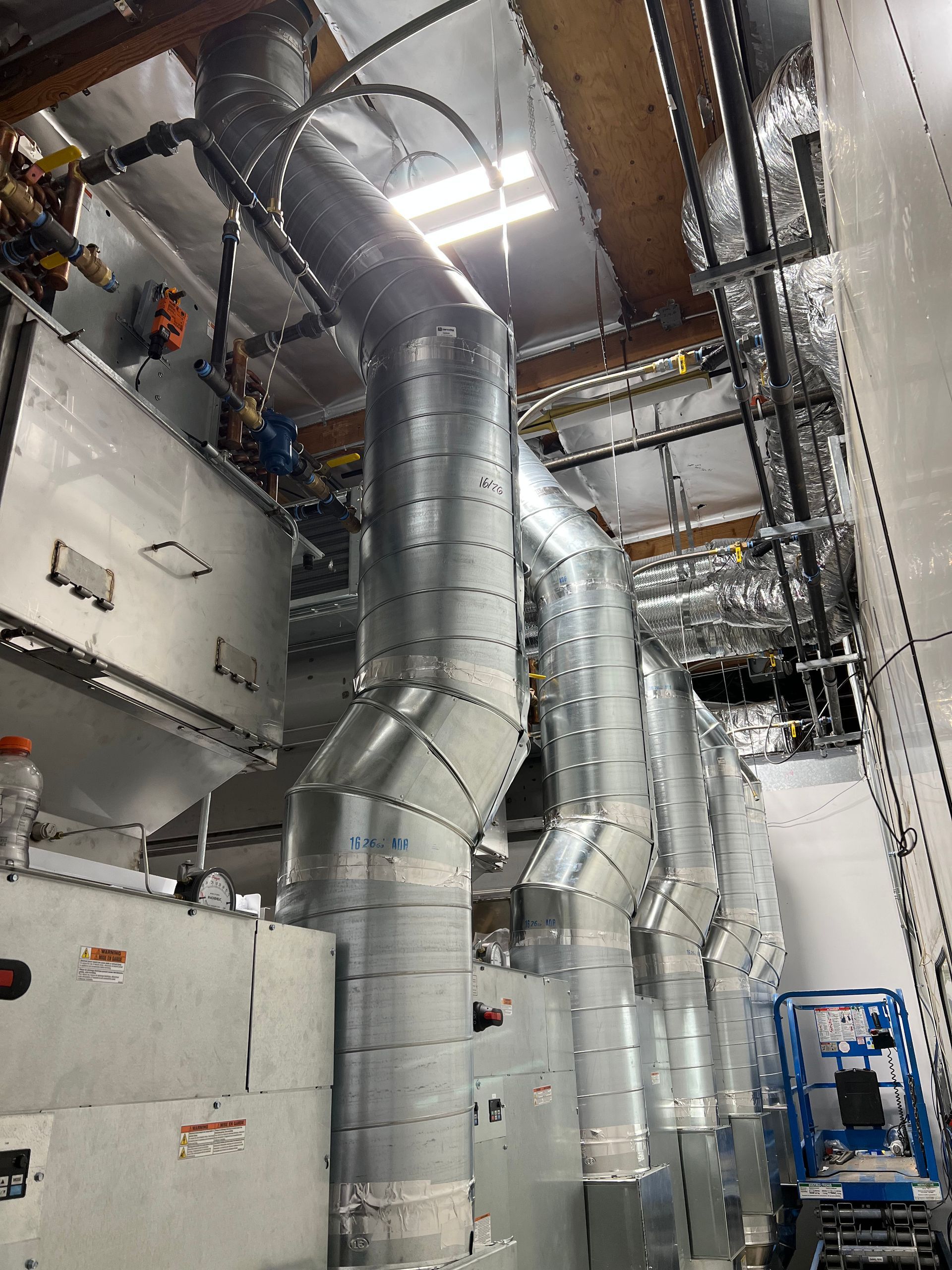 A large room with a lot of pipes hanging from the ceiling.