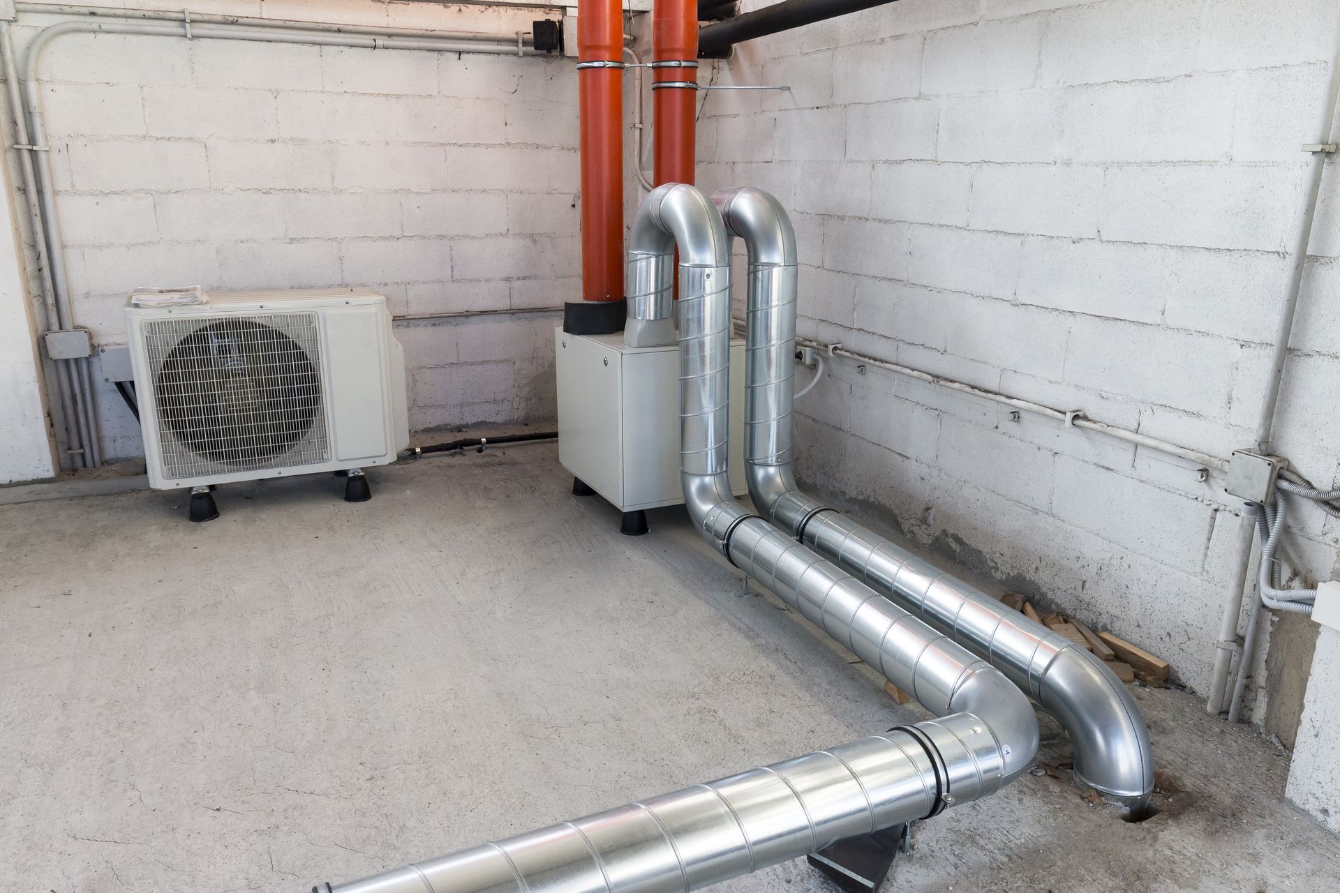 A room with a lot of pipes and a fan.