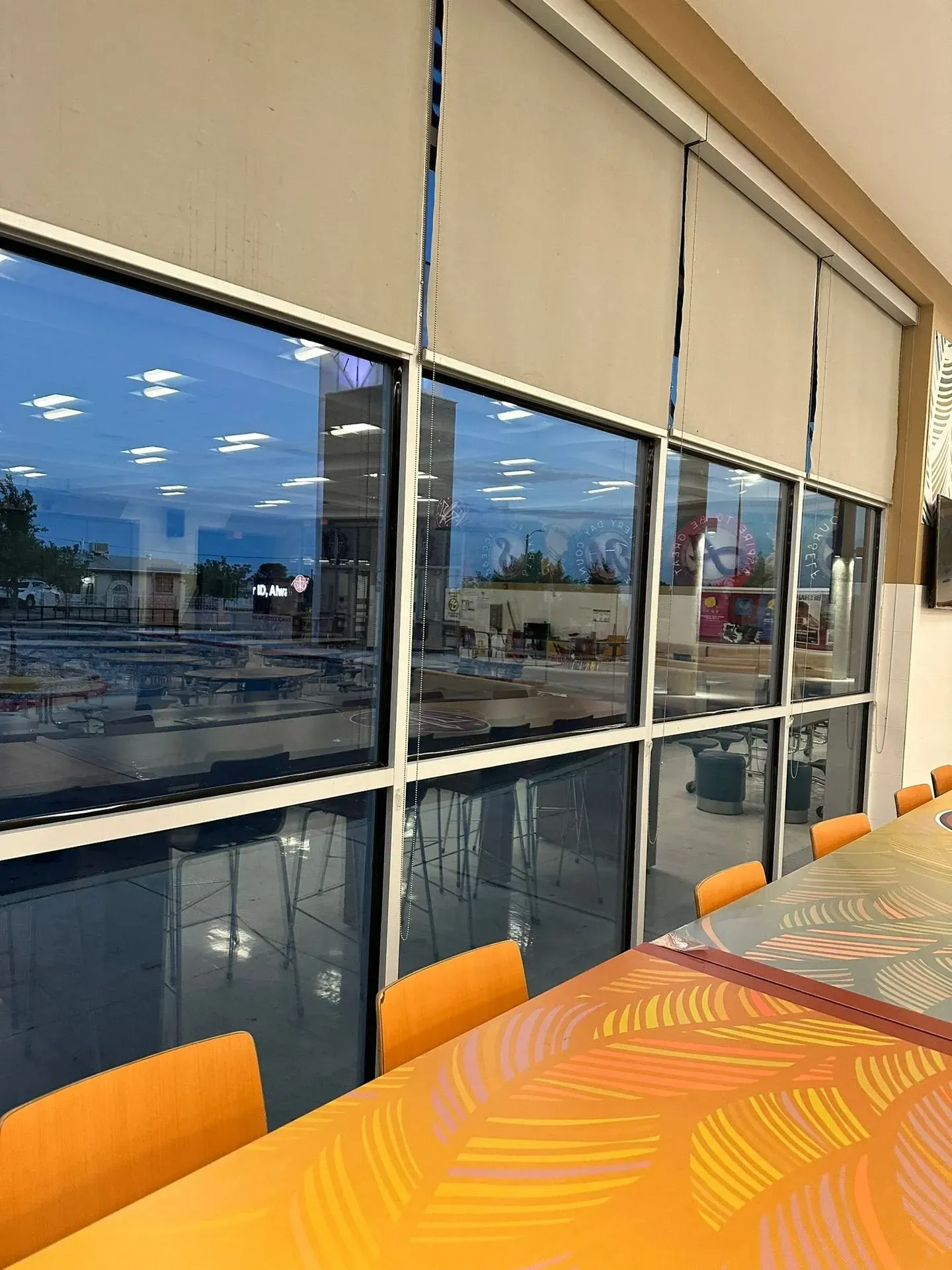 A room with a table and chairs and a lot of windows.