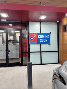A domino 's pizza restaurant with a sign that says coming soon