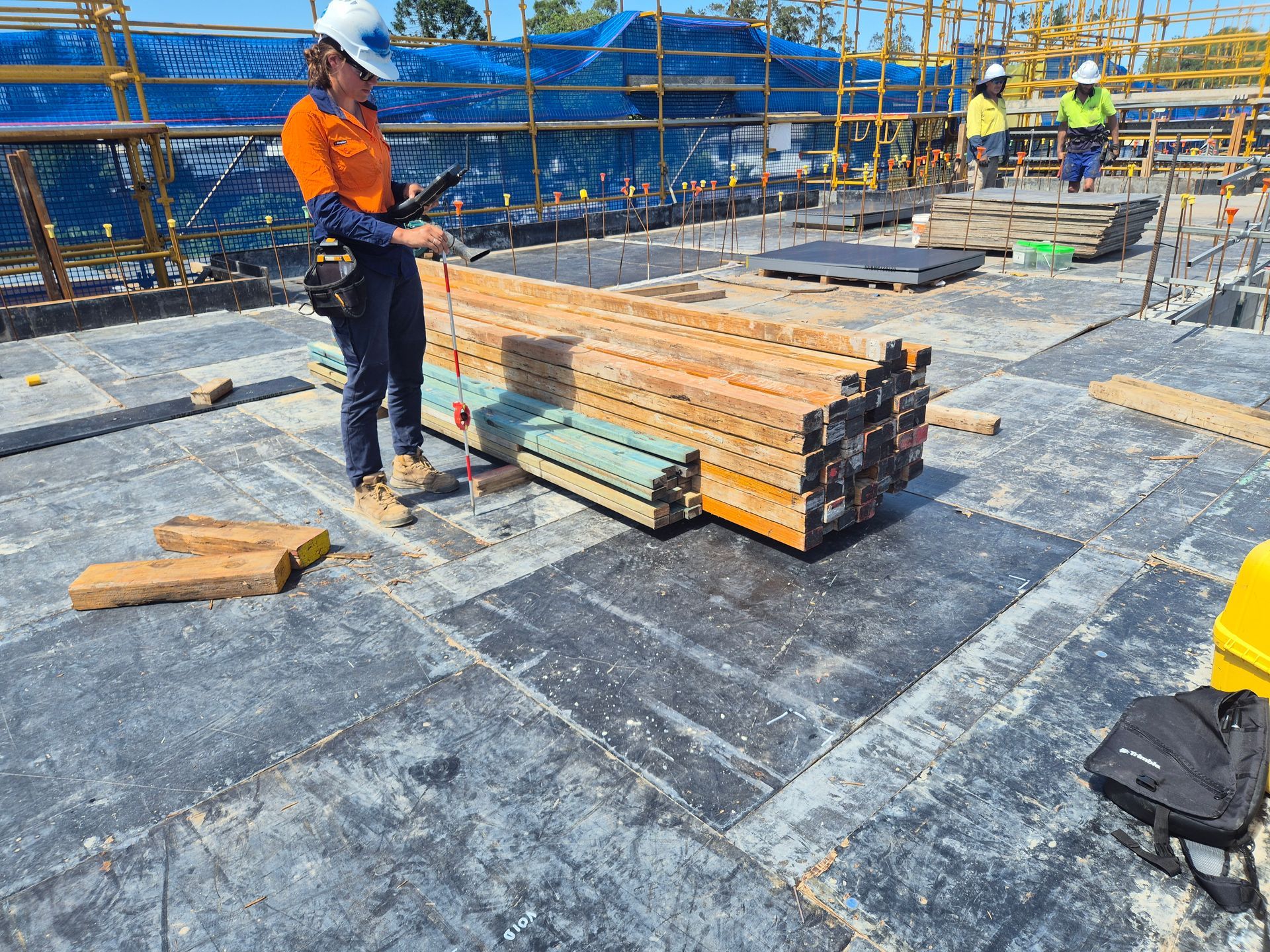 Construction Worker on a Site Inspects Lumber — Next Step Surveying in Aroona, QLD