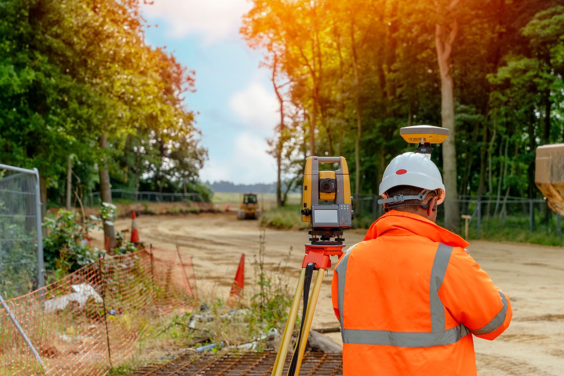 Surveyor in Orange Vest Uses Total Station — Next Step Surveying in Gympie, QLD