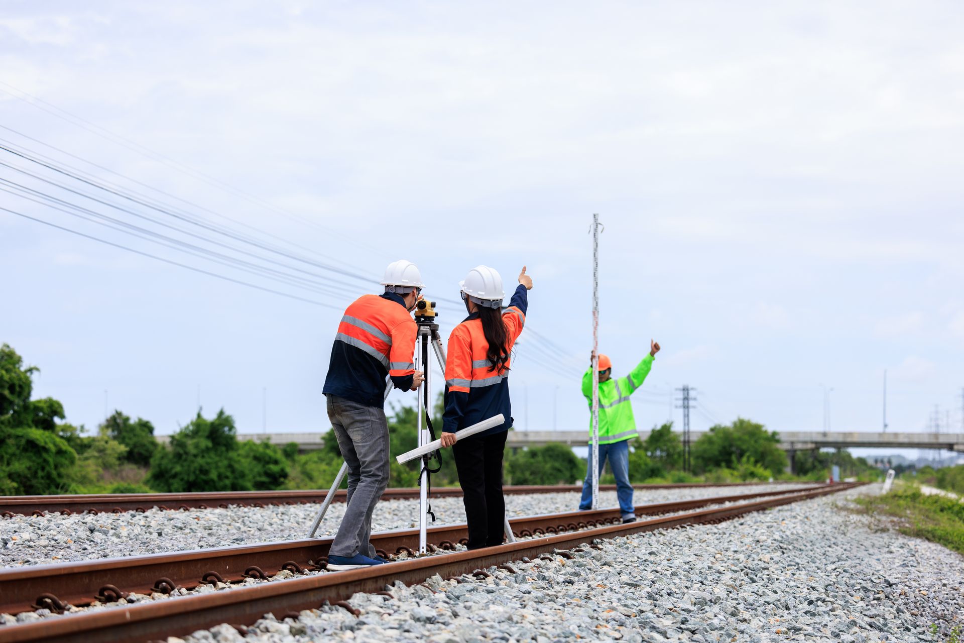 Three People Survey Railroad Tracks With Surveying Equipment — Next Step Surveying in Nambour, QLD