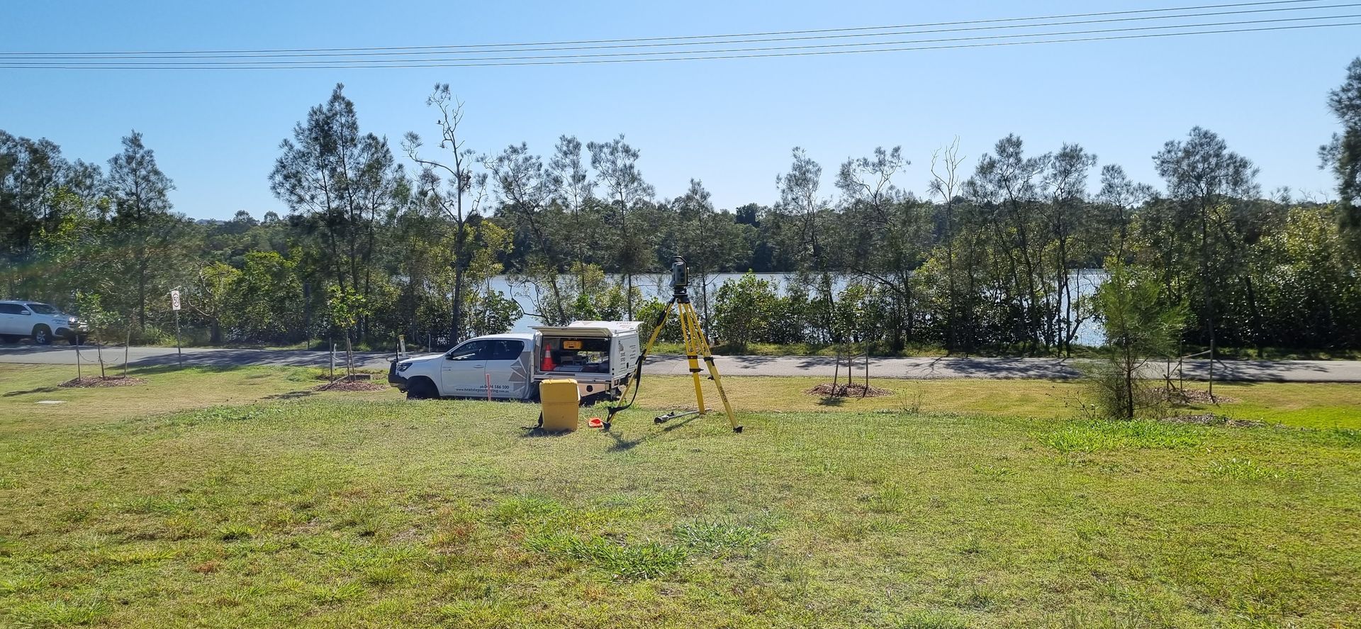 Surveying Setup on a Grassy Field Near a Road — Next Step Surveying in Moreton Bay, QLD
