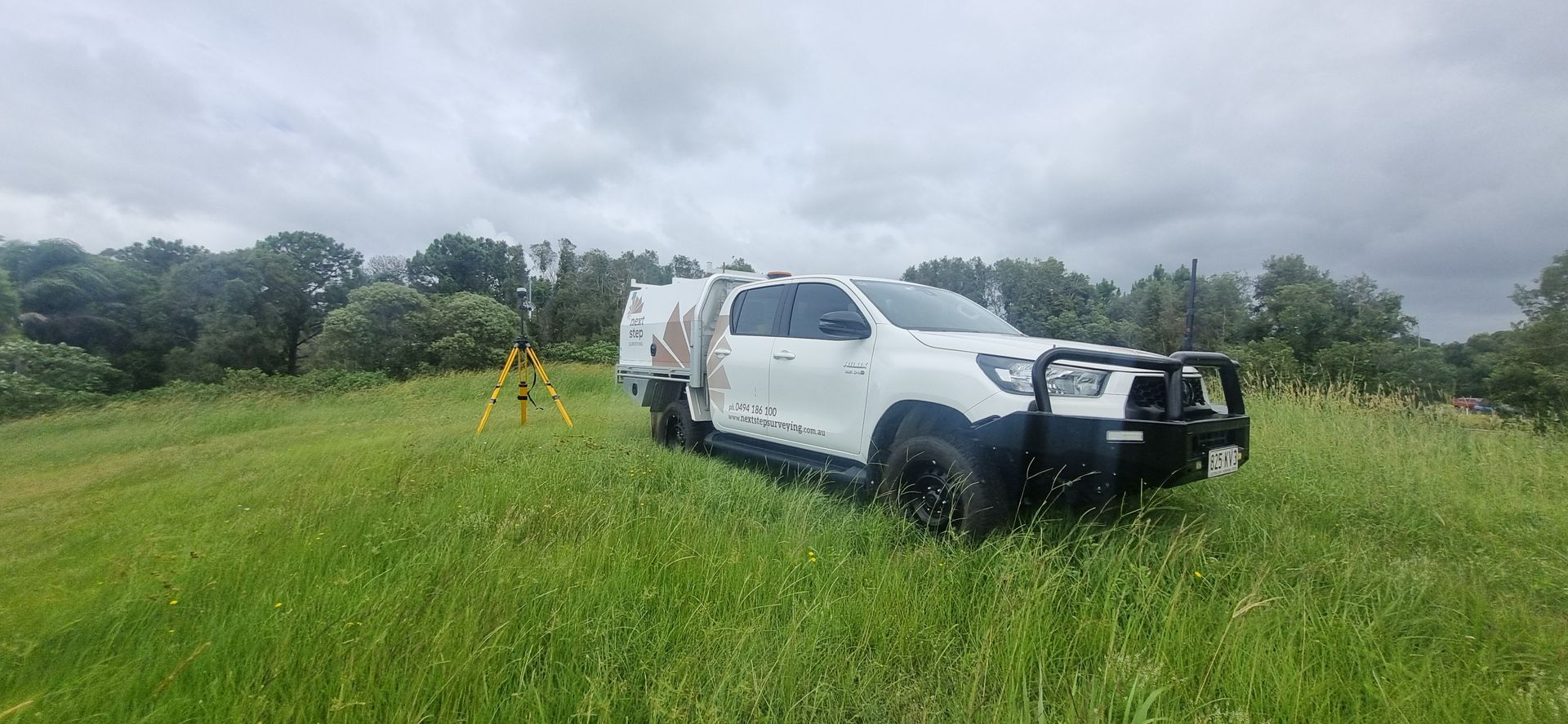 White Pickup Truck Parked in a Grassy Field — Next Step Surveying in Mooloolaba, QLD