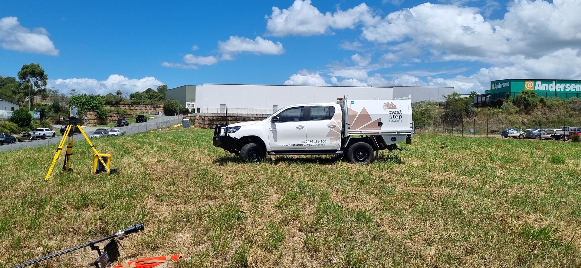 White Pickup Truck on Grassy Field, Surveying Equipment — Next Step Surveying in Ipswich, QLD