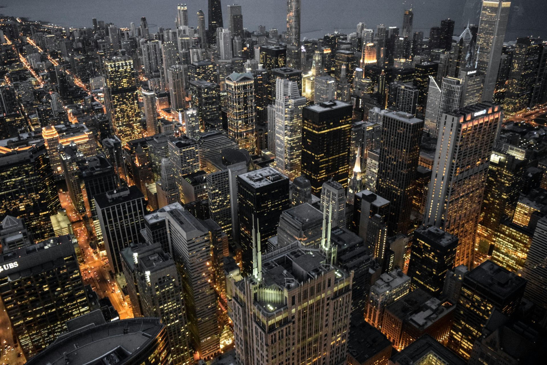 An aerial view of a city at night with lots of tall buildings