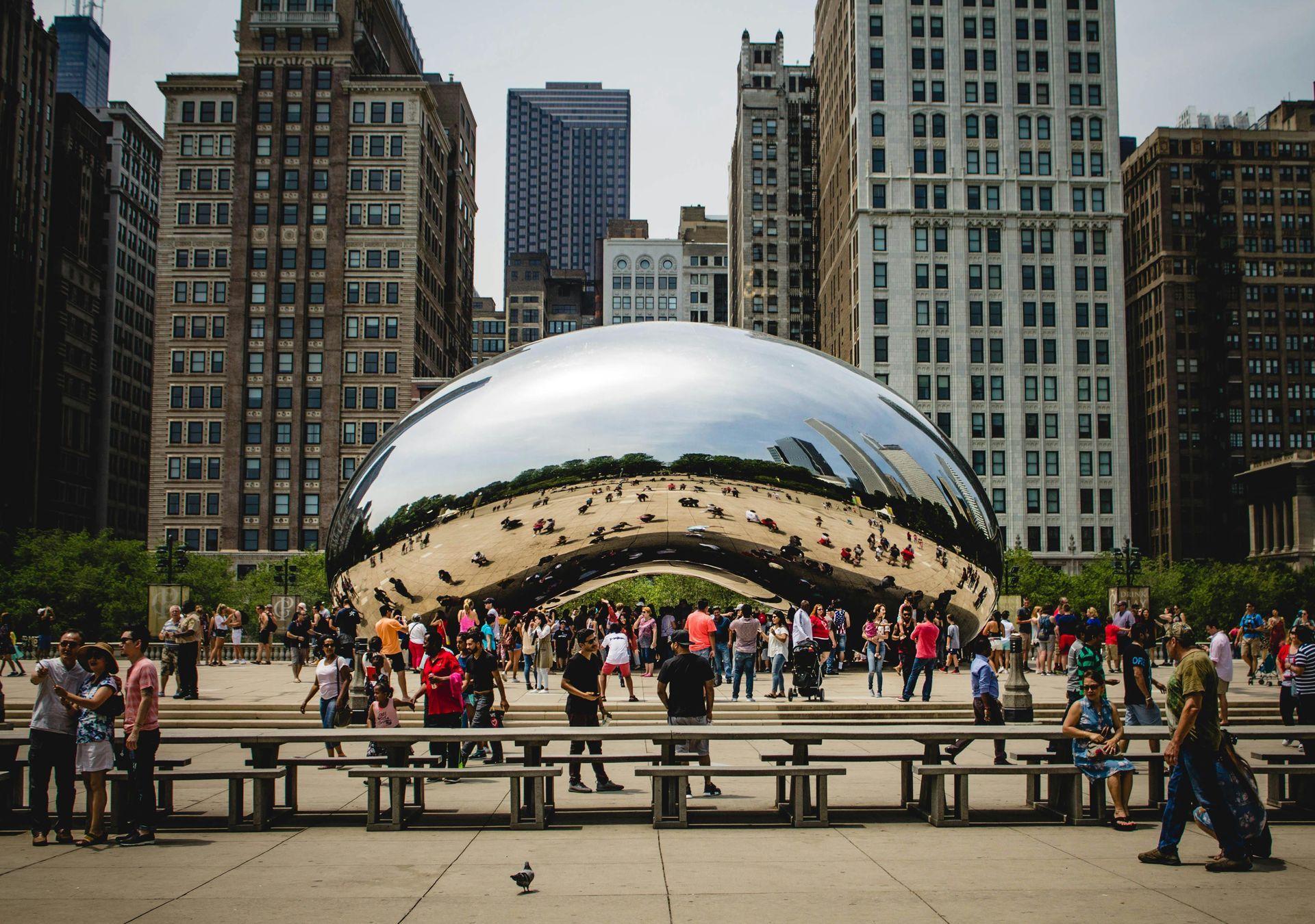 A group of people are standing in front of a large sculpture in a city.