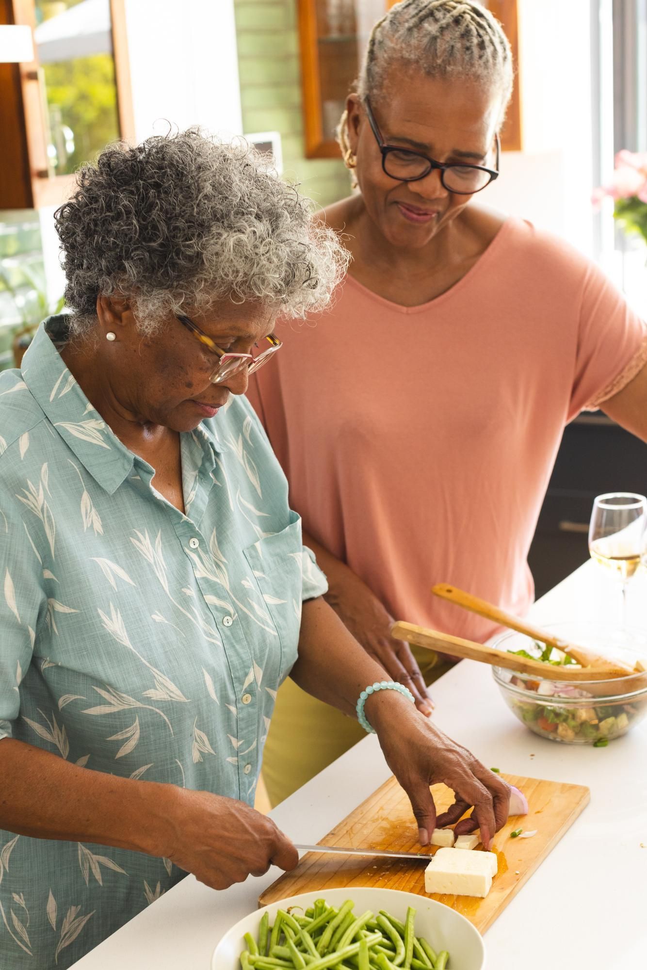 Two women are preparing food together in a kitchen.