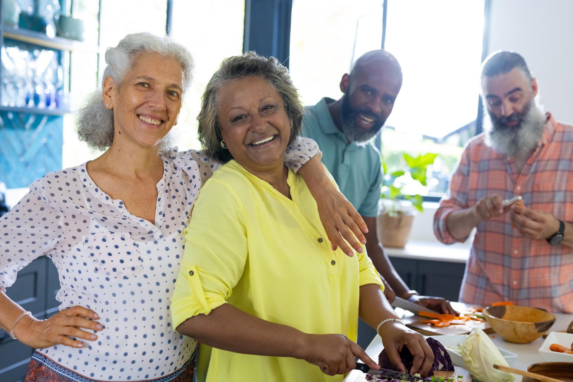 A group of people are standing in a kitchen preparing food.