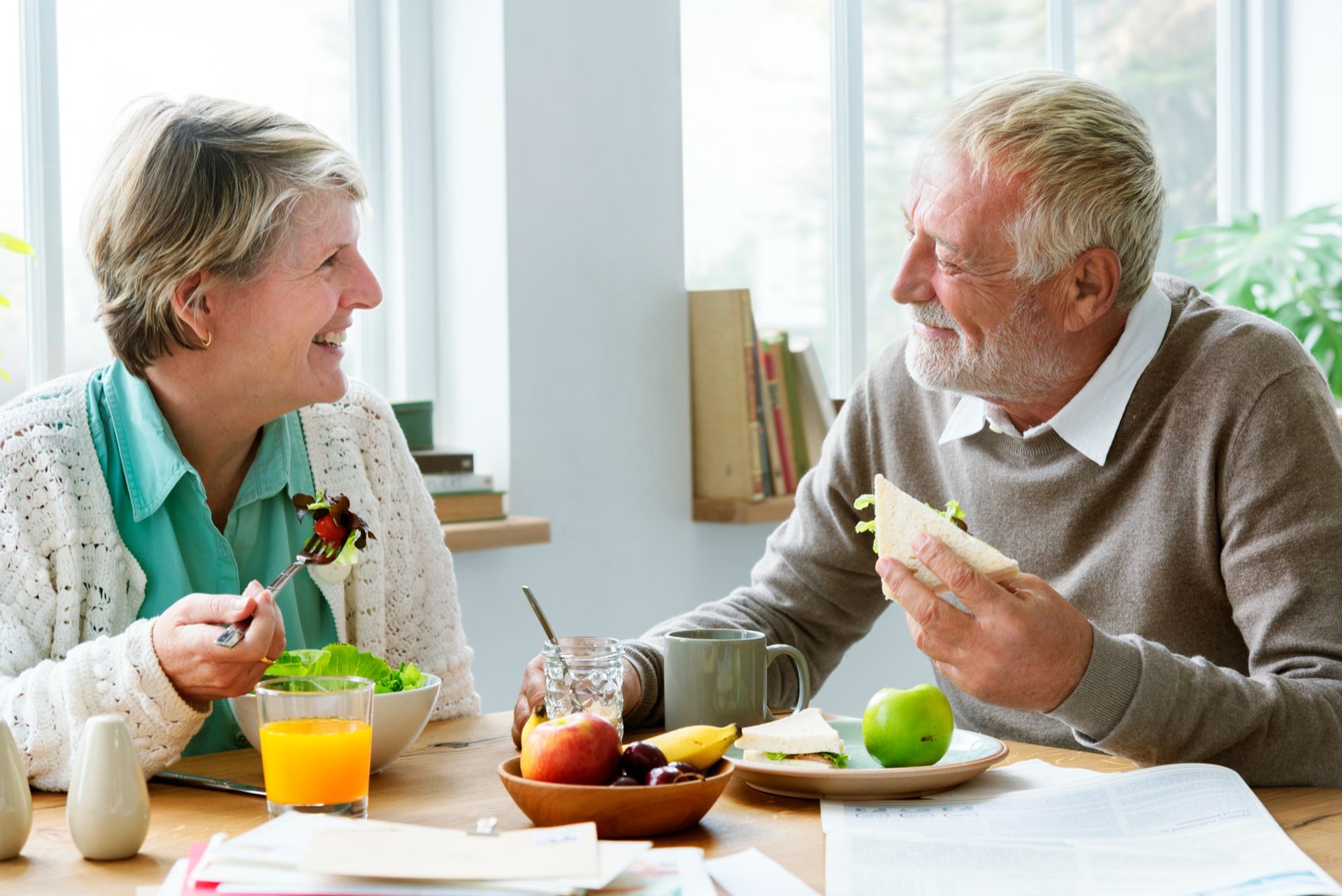A man and a woman are sitting at a table eating food.