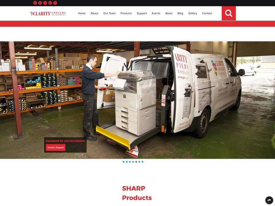 A man is loading a machine into a van that says sharp products