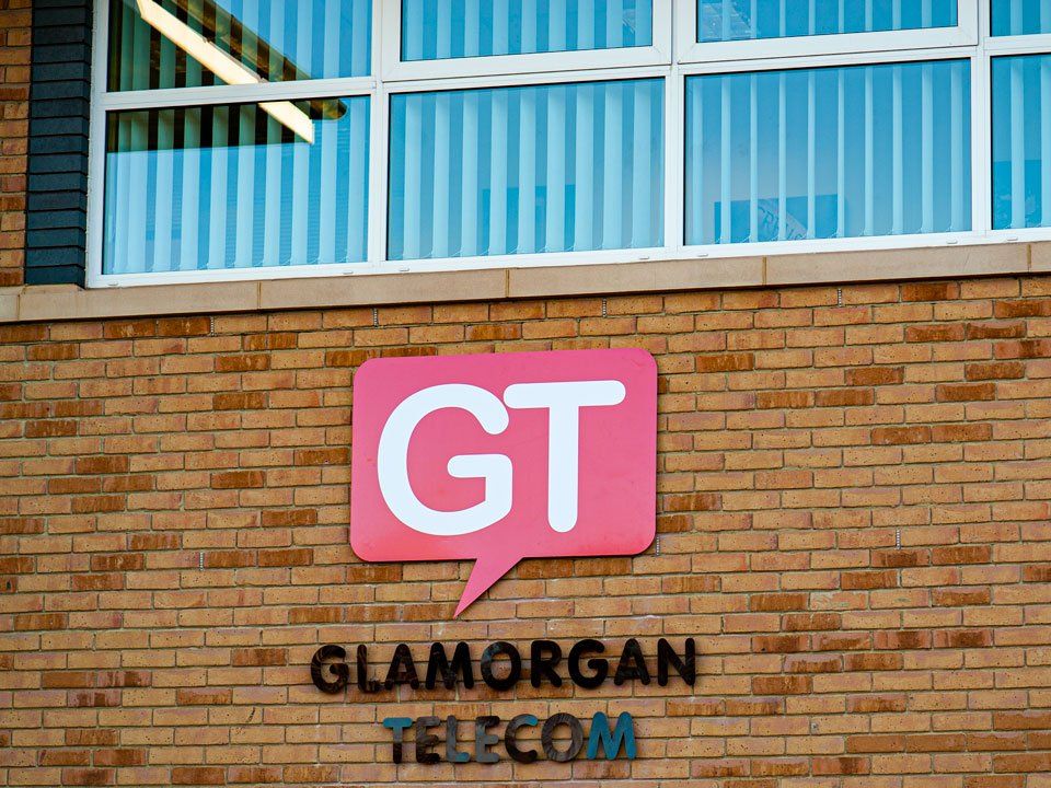 A sign for glamorgan telecom is on a brick wall