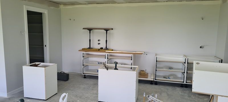 A room with white cabinets and a table in it.