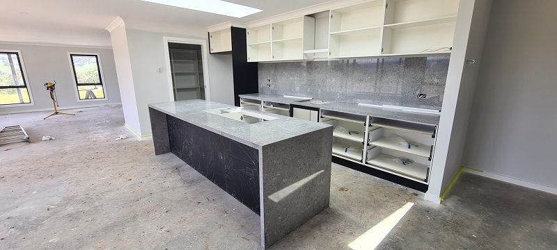 A kitchen in a house under construction with a large island in the middle.