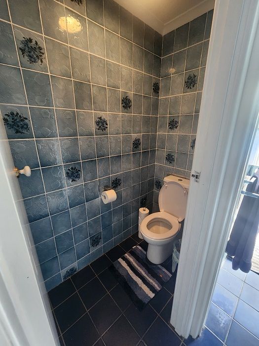 A toilet is sitting in a bathroom next to a door.