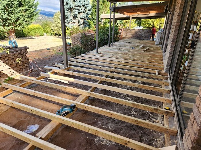A wooden deck is being built on top of a brick building.