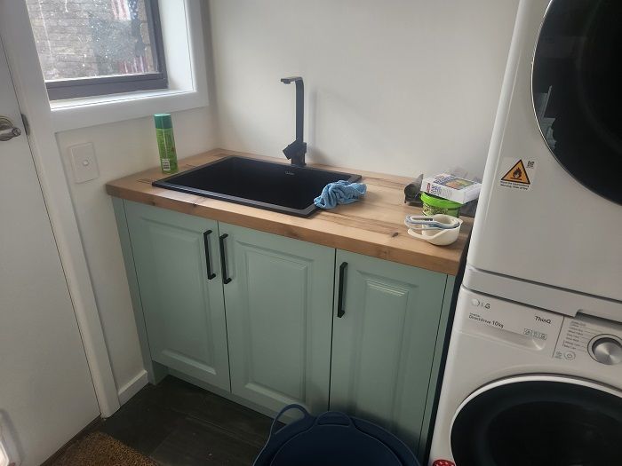 A laundry room with a sink , washer and dryer.