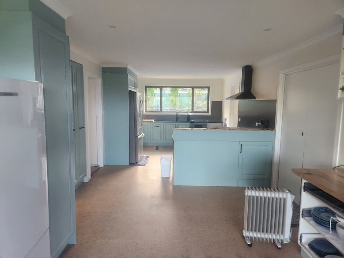A kitchen with blue cabinets and a white refrigerator