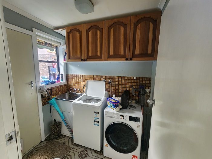A laundry room with a washer and dryer and a sink.