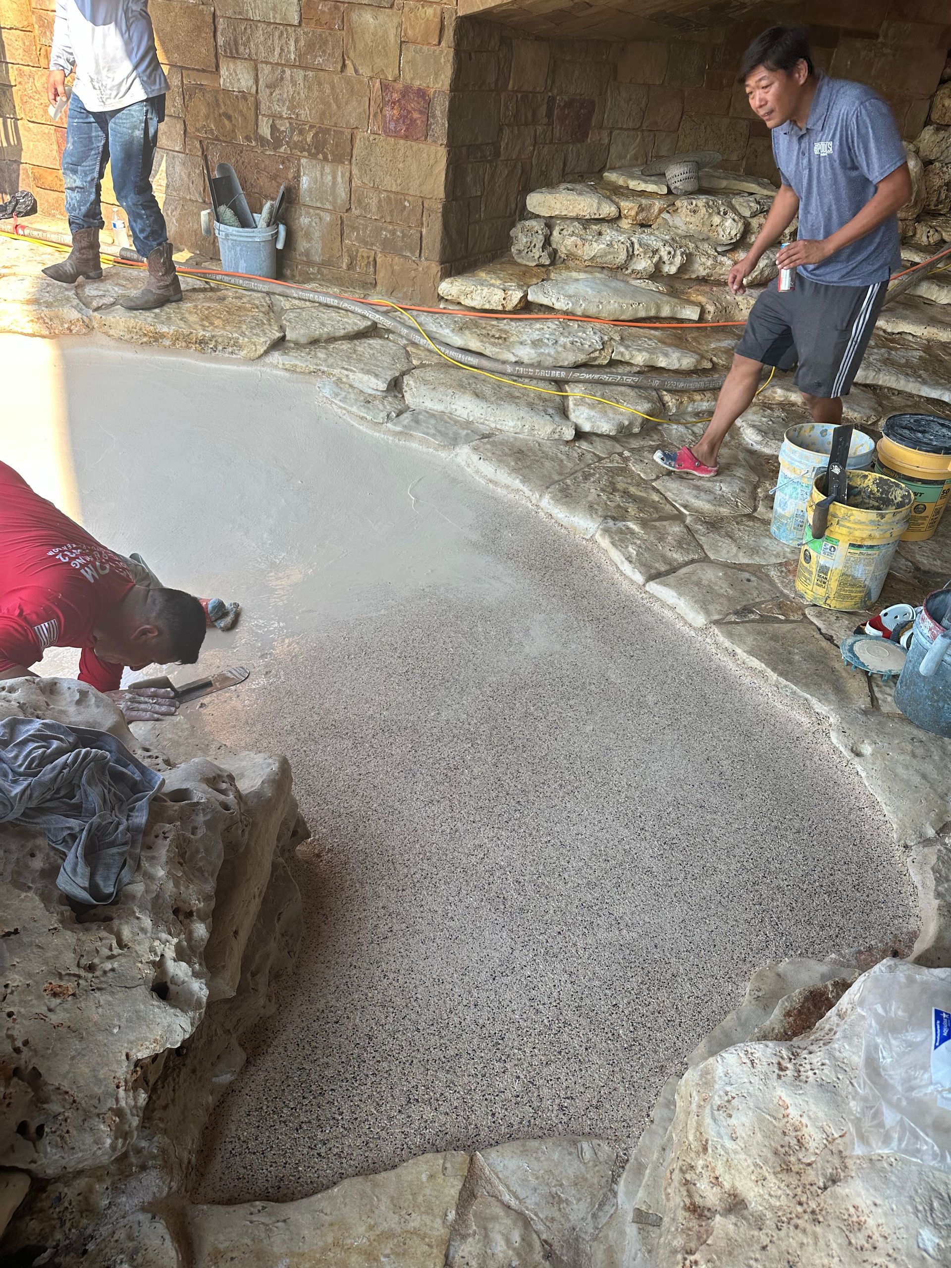 A group of men are working on a stone walkway.