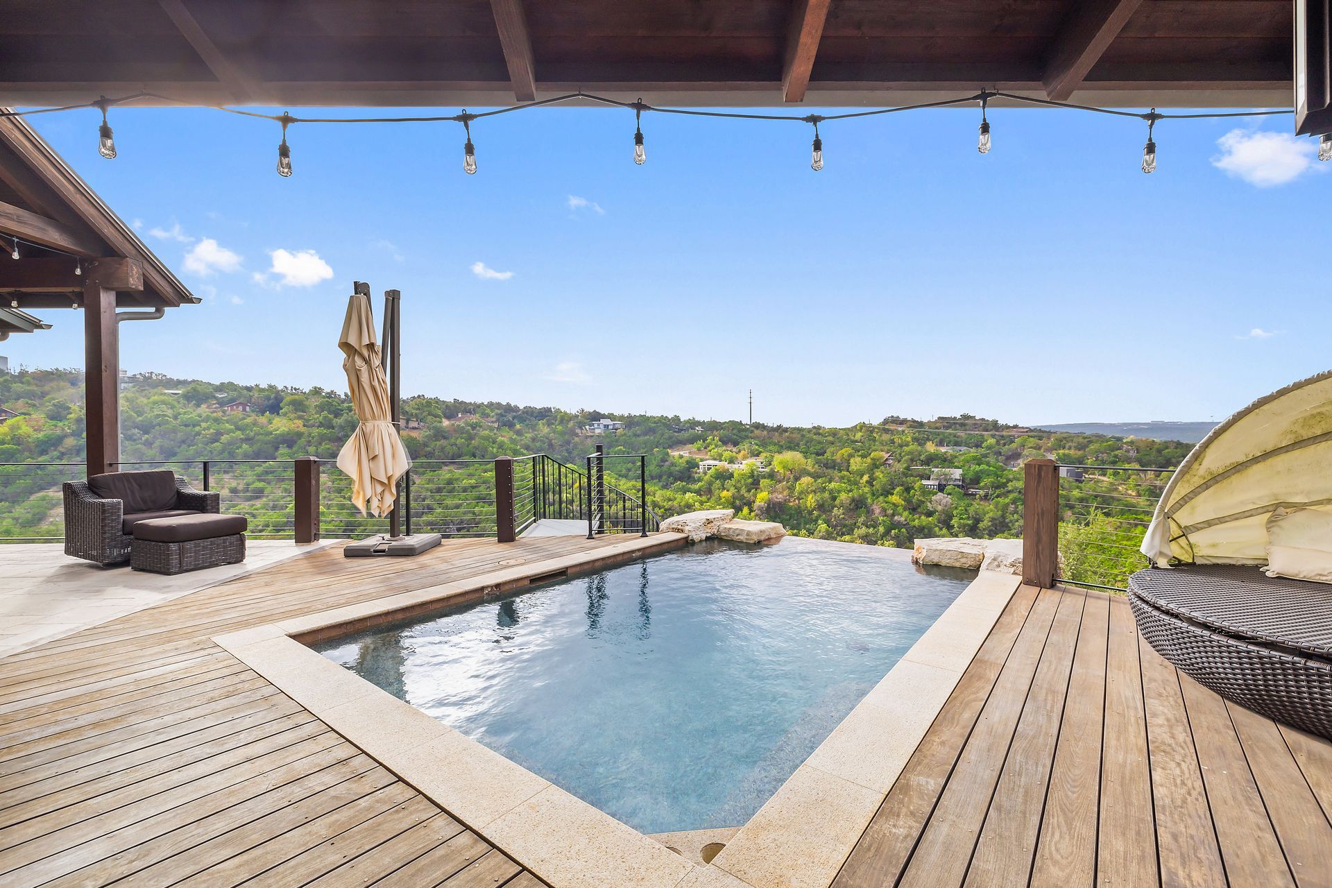 A large swimming pool is surrounded by a wooden deck.