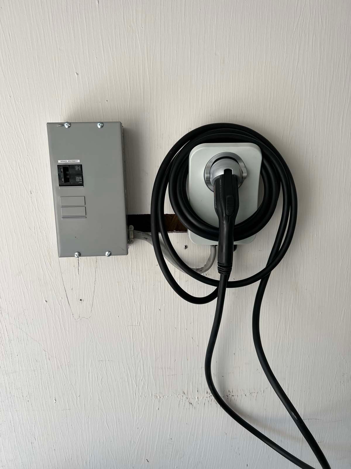 A black cord is plugged into a wall outlet.