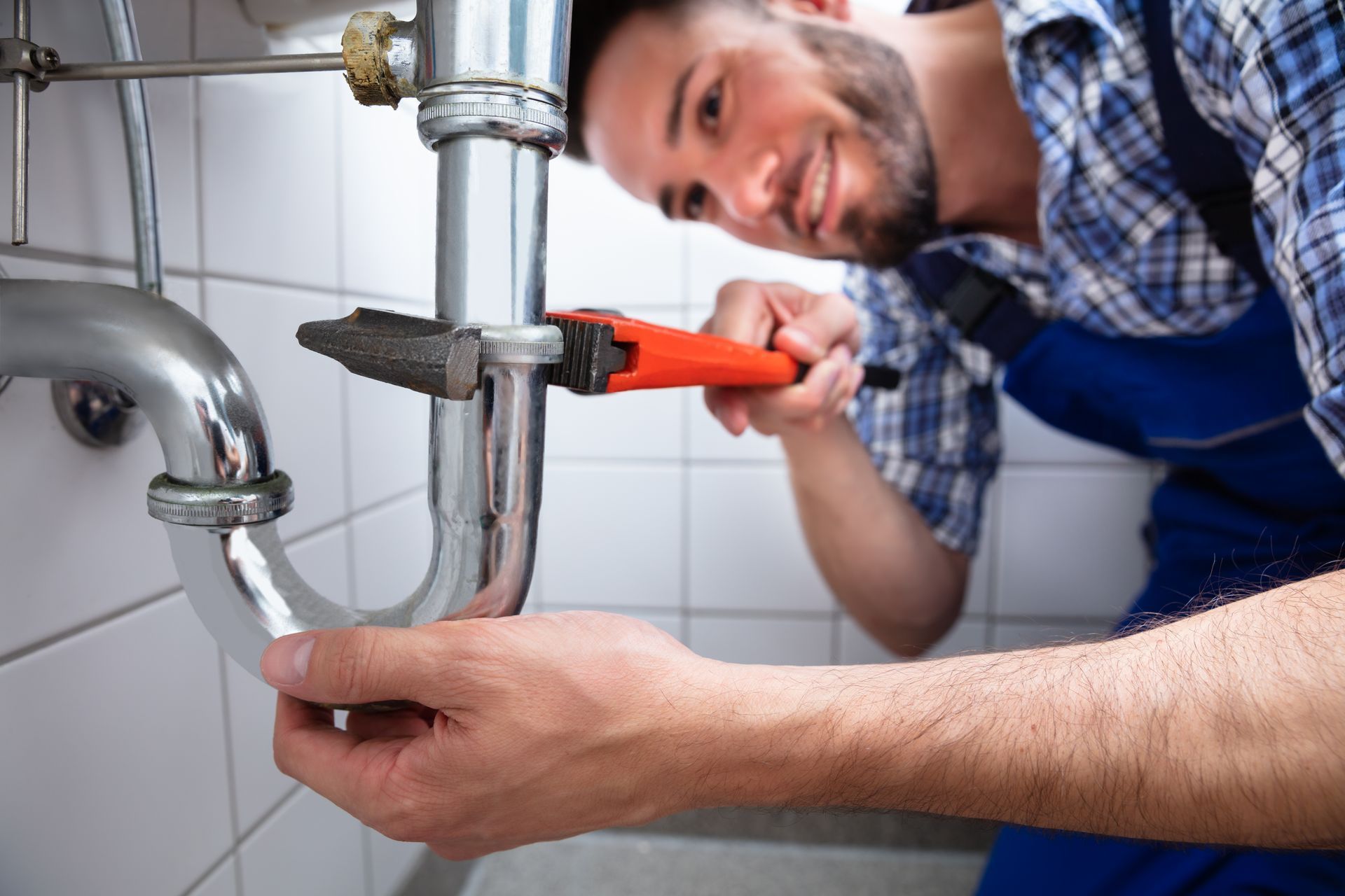 Plumber Repairing Sink With Adjustable Wrench In Bathroom — Kogarah, NSW — One Touch Plumbing
