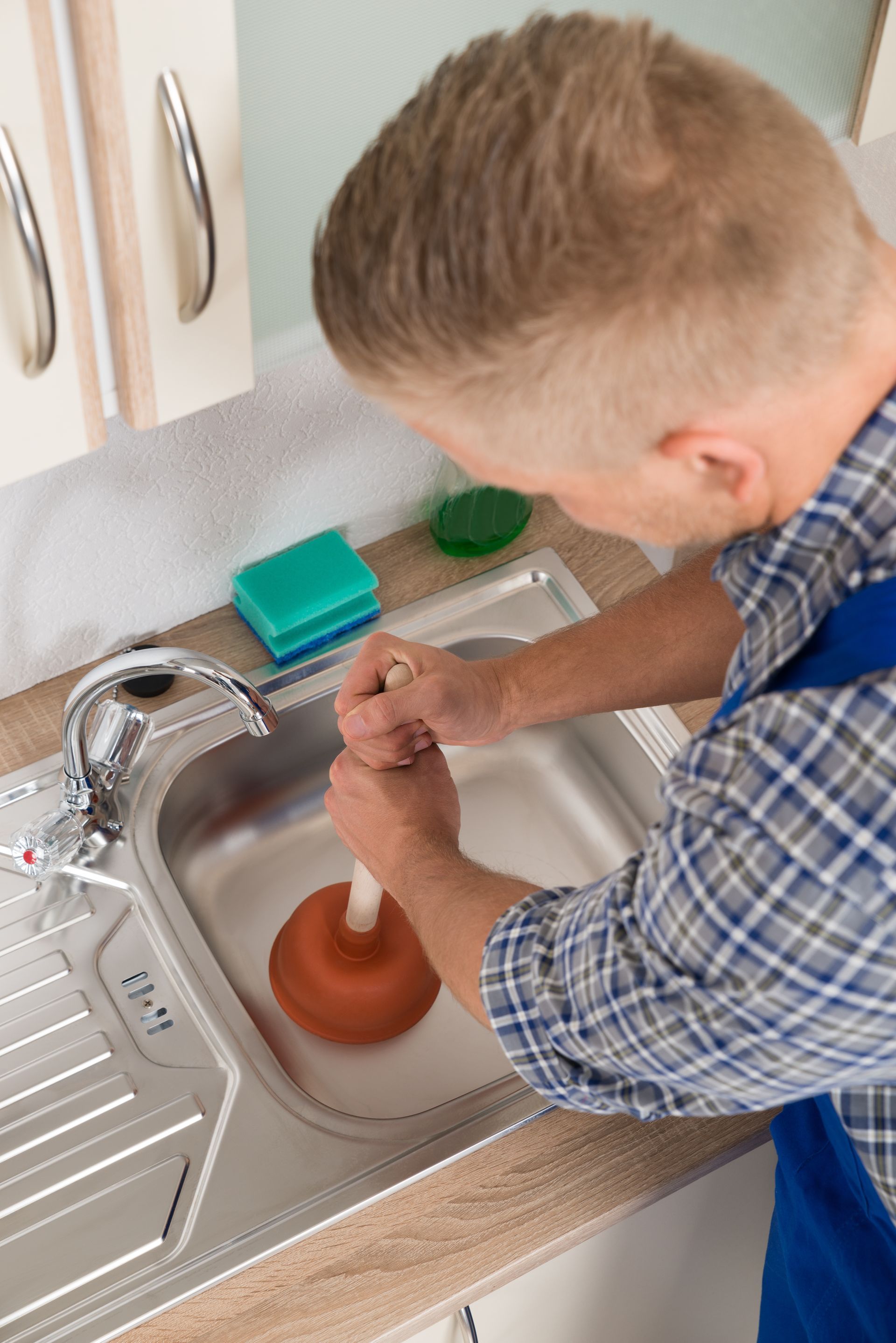 Plumber Using A Pipe Plunger To Fix Kitchen Sink — Kogarah, NSW — One Touch Plumbing