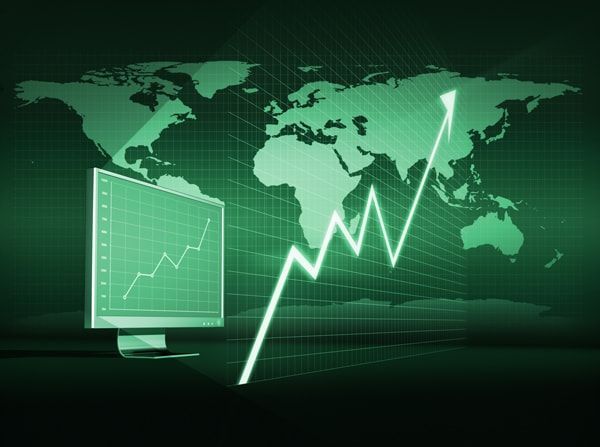 A computer monitor with a graph on it in front of a map of the world