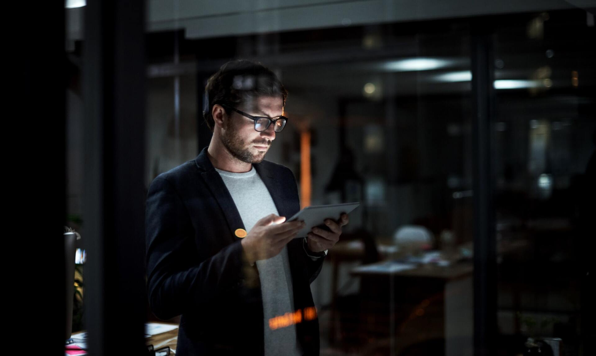 uomo con occhiali da vista che guarda tablet