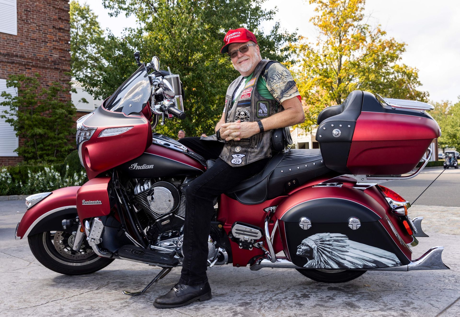 A man is sitting on a red motorcycle.