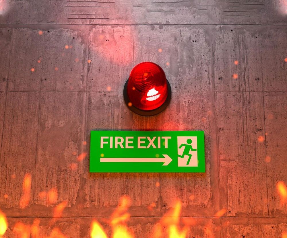 A fire exit sign is hanging on a wall next to a red light.