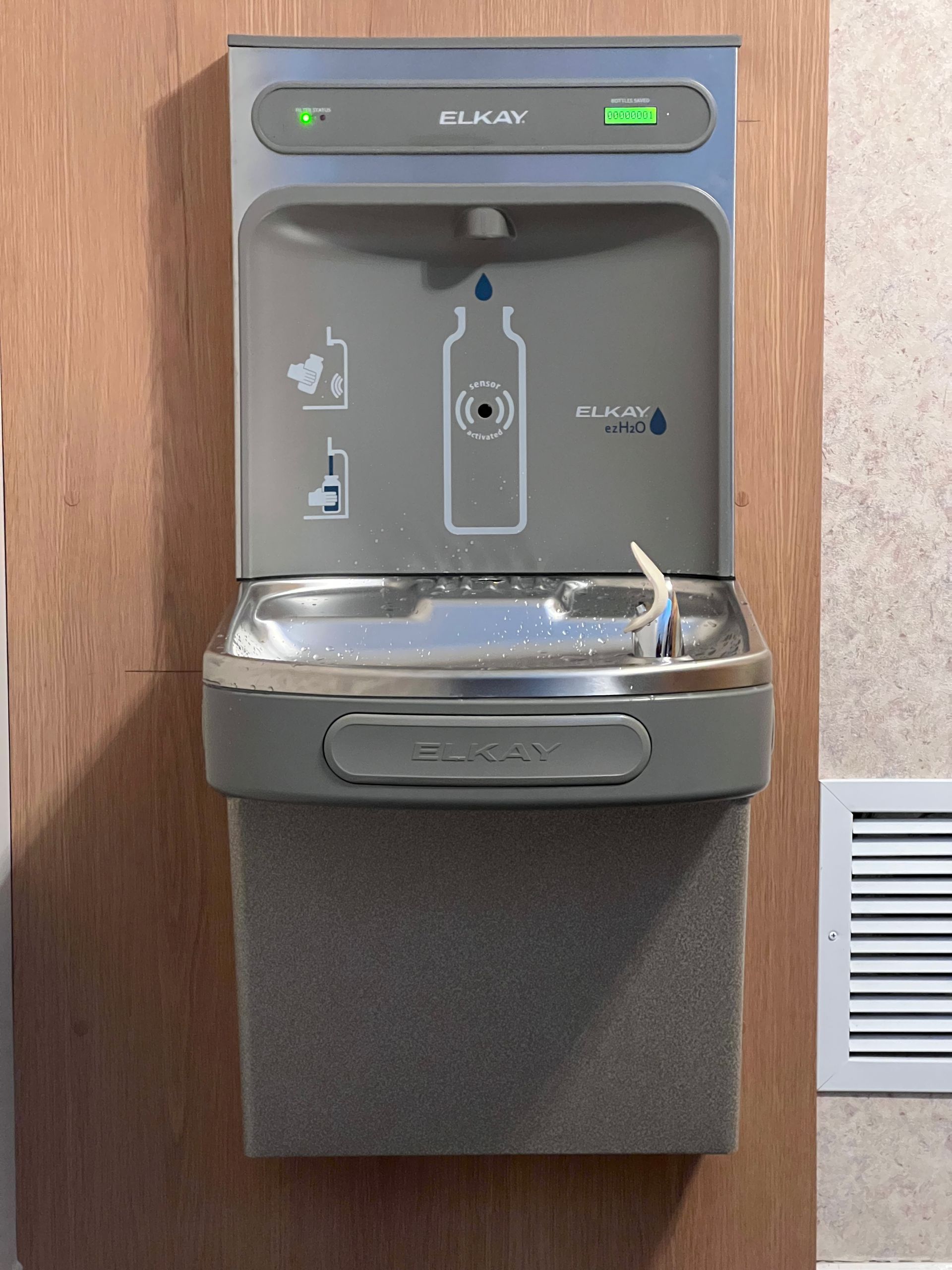 A water fountain with a picture of a bottle on it