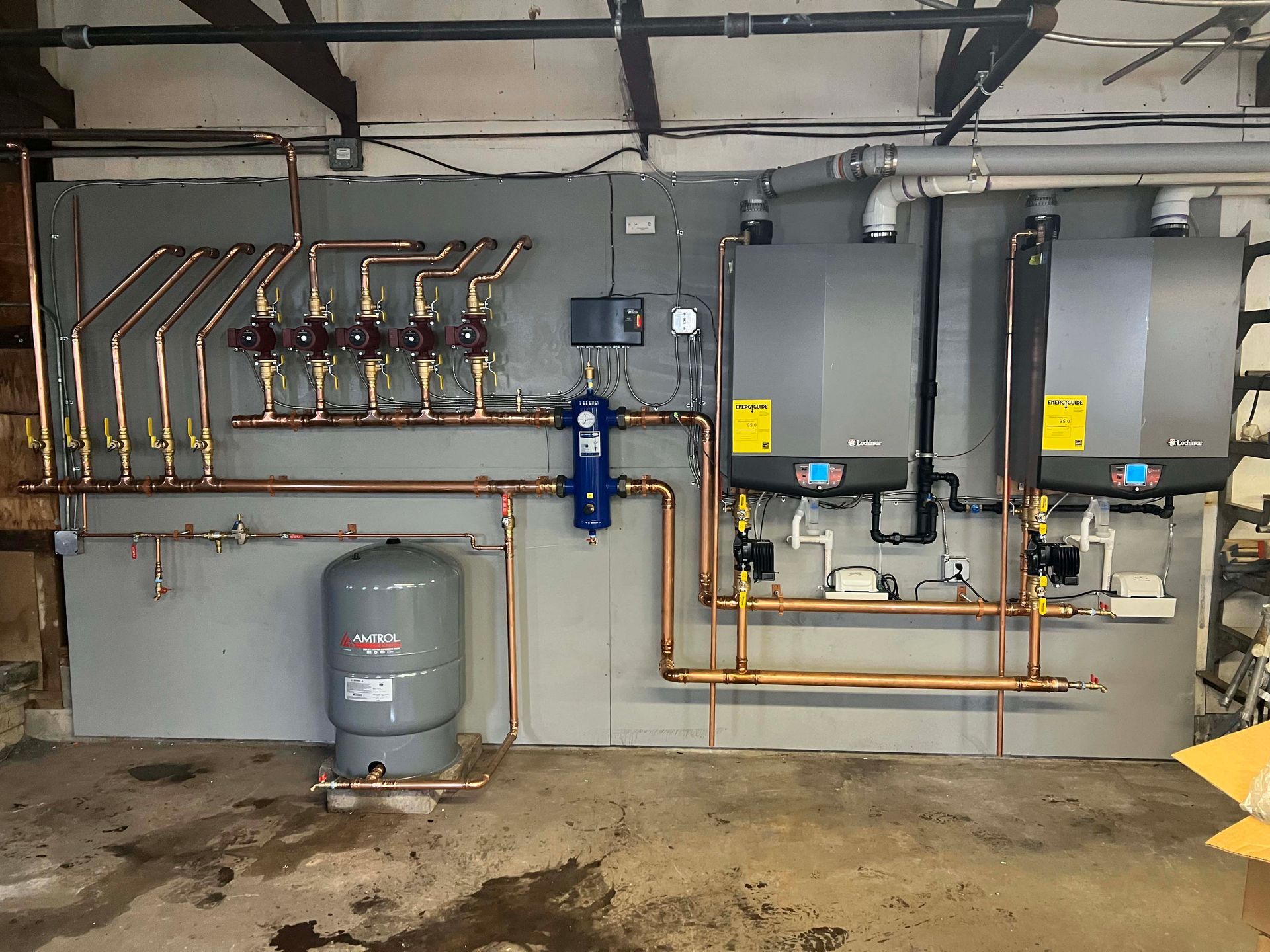 A room with a lot of pipes and boilers on the wall.
