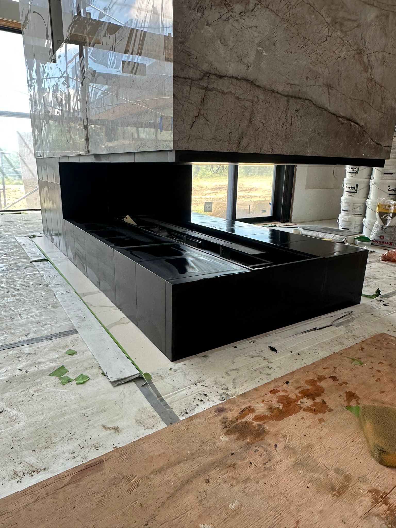 White kitchen cabinets installed in a room with light-colored flooring; construction in progress.