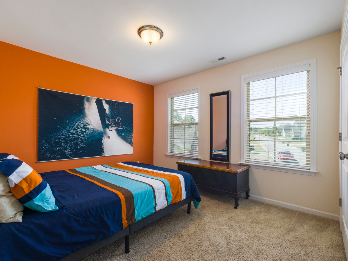 Bank building with cars parked out front on a sunny day. Green lawn and blue sky.